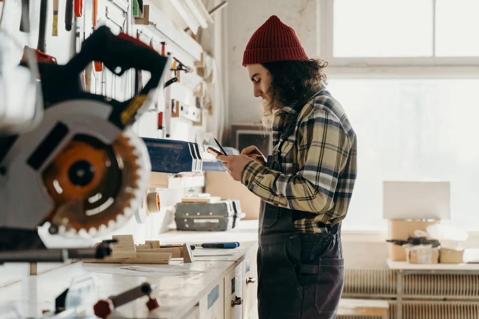 Une artisane consulte son téléphone dans son atelier